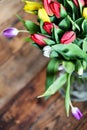 Flower background: bouquet of colorful tulips in a glass vase on a natural wooden background, postcard, mocap for mother's day gr Royalty Free Stock Photo