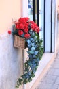 flower basket with red flowers as an outdoor decoration closeup photo on house window background Royalty Free Stock Photo