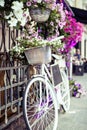 Flower in basket of vintage bicycle on vintage wooden house wall, summer street cafe Royalty Free Stock Photo