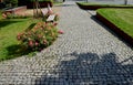 The flower bed is bordered by a rusty sheet metal design. perennials and grass bloom in the flowerbed. paving stone cubes between Royalty Free Stock Photo