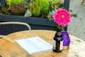 Flower in a bottle, candle and menus on the table