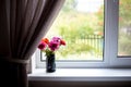 Bunch of automn flowers in vase on the window of living room interior