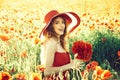 Flower bouquet at smiling girl in retro hat, poppy field