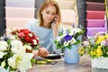 Flower delivery service. florist seller with a telephone. Interior colors