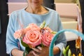 Floral business. Woman collecting a bouquet of roses. The order and delivery of fresh flowers. Royalty Free Stock Photo