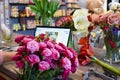 Floral business. Woman collecting a bouquet of roses. The order and delivery of fresh flowers. Royalty Free Stock Photo