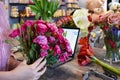 Floral business. Woman collecting a bouquet of roses. The order and delivery of fresh flowers. Royalty Free Stock Photo