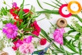 Flower composition with a bouquet of pink peony flowers, cornflowers and red roses and colored ribbons on a white background, top Royalty Free Stock Photo