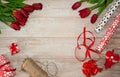 A bouquet of spring red tulips, gift boxes, wrapping paper, ribbons and bows on a light wooden background Royalty Free Stock Photo