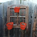 Empty red buckets hanging on a wooden gate