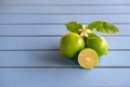 Flower, cut and whole limes on blue wooden background Royalty Free Stock Photo