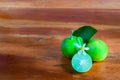 Flower, cut and whole limes on wooden background Royalty Free Stock Photo