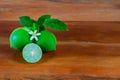 Flower, cut and whole limes on wooden background Royalty Free Stock Photo