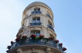 The flower-decked facade of raditional French house with typical balconies and windows. Paris.