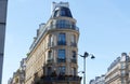 The flower-decked facade of traditional French house with typical balconies and windows. Paris.