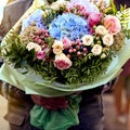 Flower delivery on order. Courier holds a beautiful bouquet of flowers for the customer. Service concept