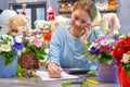 Flower delivery service. florist seller with a telephone. Interior colors