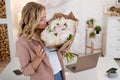 Flower delivery, a young beautiful blonde with a bouquet of peonies.