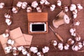 Flower design with fluffy dried cotton bolls gift boxes, white smartphone and jute rope hank over rough brown burlap Top