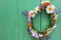 Flower door wreath. Midsummer flower crown on rustic wooden background with copy space. DIY floral wreath. Royalty Free Stock Photo