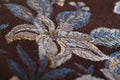 Embroidered flower design on a brown cloth