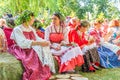 Flower Festival. Girls in national Russian costumes are sitting on straw bundles