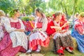 Flower Festival. Girls in national Russian costumes are sitting on straw bundles