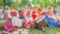 Flower Festival. Girls in national Russian costumes are sitting on straw bundles