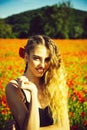 Flower field. fashion portrait of a sensual girl. poppy seed and girl with long curly hair