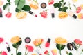 Flower frame with rose flowers, petals and make up cosmetics on white background. Flat lay Royalty Free Stock Photo