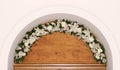 A flower garland of cream roses and chrysanthemums in an arch above the door in the church as a decoration of the holiday. Profess Royalty Free Stock Photo