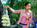 A young girl sells flower garlands at a temple in Burma