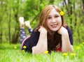 Flower Girl lying in a flower meadow with Dandelions with wild flowers and bare feet Royalty Free Stock Photo