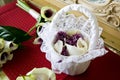 A flower girls white basket full of purple flowers and white rose petals