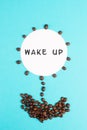 Flower made with coffee beans, the words wake up are standing on the blossom, good morning, having an espresso for breakfast