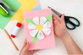 A flower made of cotton pads. Colored paper, stapler, scissors, scissors, pencil on a white table. Children`s craft card for Royalty Free Stock Photo