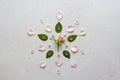 Flower Mandala on Gray Background. Geometrical floral composition. Rose laid out on the petals. Stones rose quartz and rock