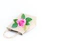 Flower pink rose on the brown paper bag isolated on the white b Royalty Free Stock Photo
