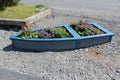 A flower planter in the shape of a dory or rowboat along a waterfront path in Nova Scotia