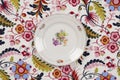 Flower plate hidden on a flowery fabric