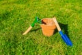 Flower pot empty with blue shovel in fresh green grass background texture, Garden,spring,hobby,potting concept copy space