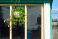 The flower pot is suspended on the roof of a private house on the background of the reflection in the window of the trees of the f Royalty Free Stock Photo