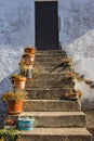 Flower pots nn outdoor stairs with close door. Patio design. Traditional backyard in Europe. Flowers on outdoor steps. Royalty Free Stock Photo