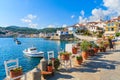 Flower pots on and view of fishing boats anchoring in Kokkari bay, Samos island, Greece Royalty Free Stock Photo