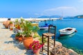 Flower pots on and view of fishing boats anchoring in Kokkari bay, Samos island, Greece Royalty Free Stock Photo