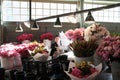 Flower seller behind pink and red bouquets in Pike Place Market