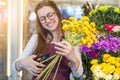 Flower seller, young woman standing at shop with flower in hands Royalty Free Stock Photo