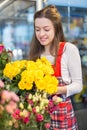 Flower seller, young woman standing at shop with flower in hands Royalty Free Stock Photo