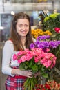 Flower seller, young woman standing at shop with flower in hands Royalty Free Stock Photo