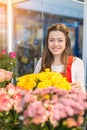 Flower seller, young woman standing at shop with flower in hands Royalty Free Stock Photo